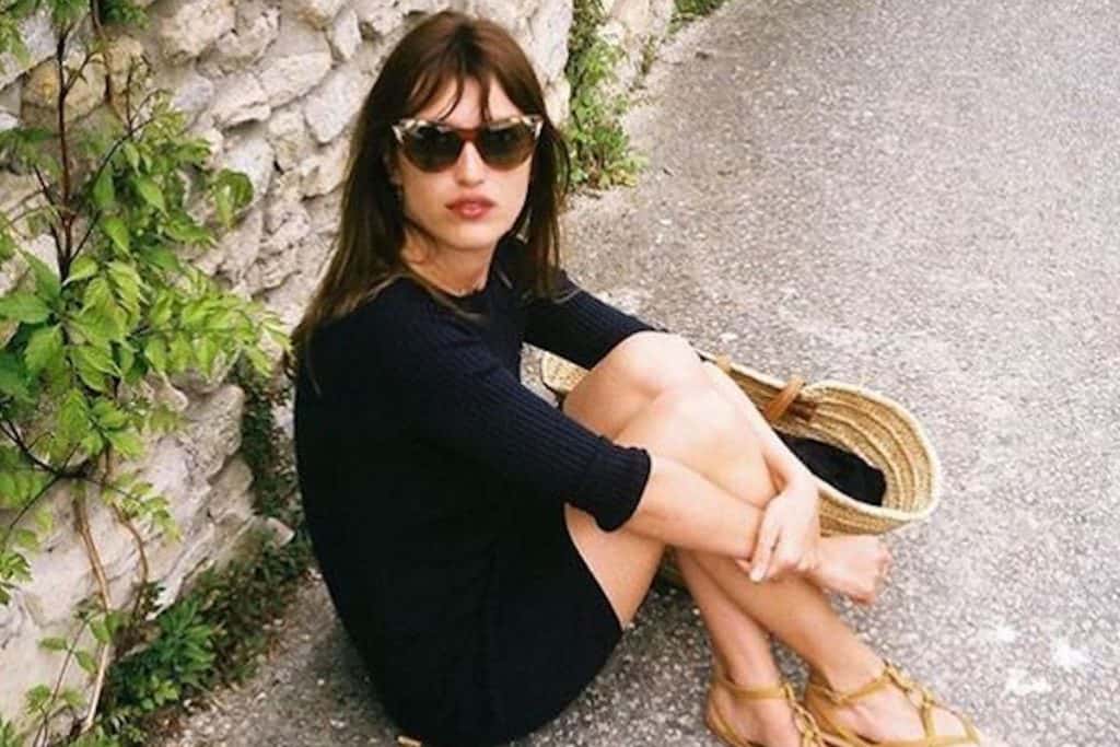jeanne damas wearing sunglasses and a black dress