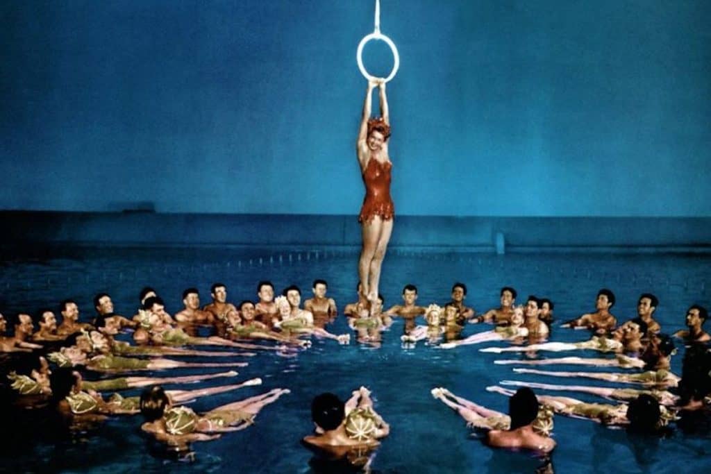 a vintage image of a woman in a swimsuit hanging over a pool