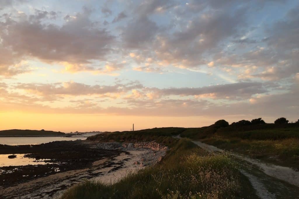 a sandy shoreline at sunset