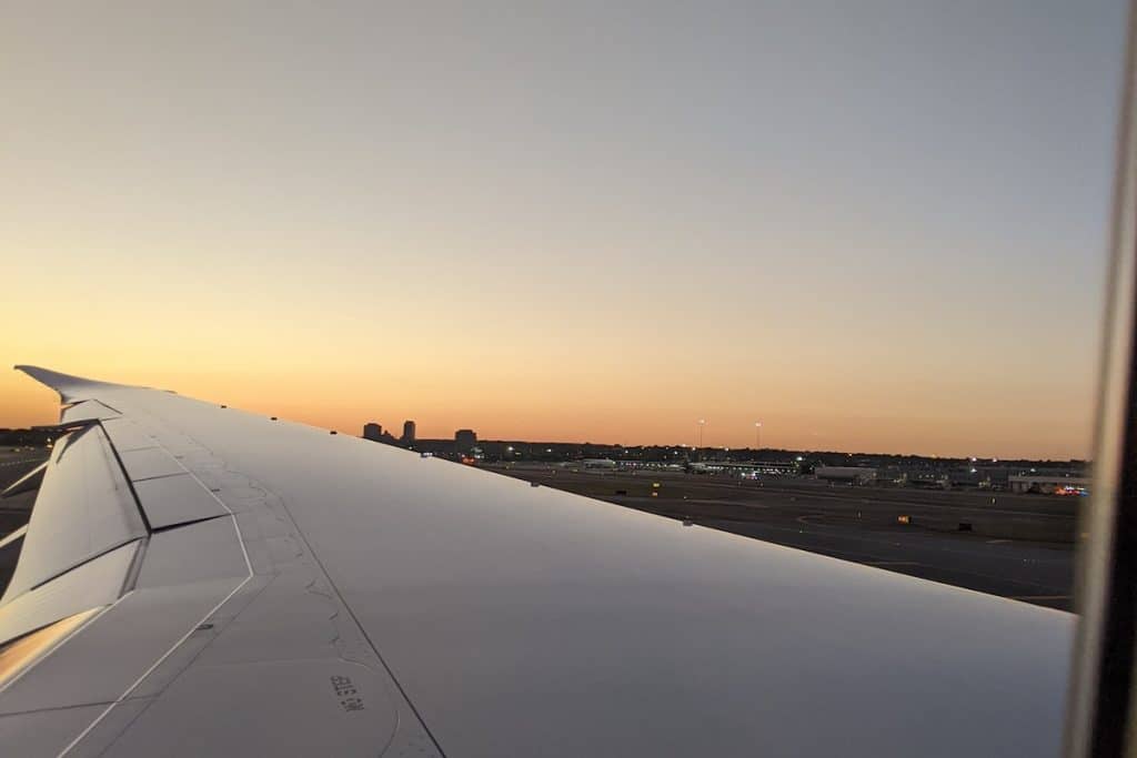 the image of the wing of a plane at sunset