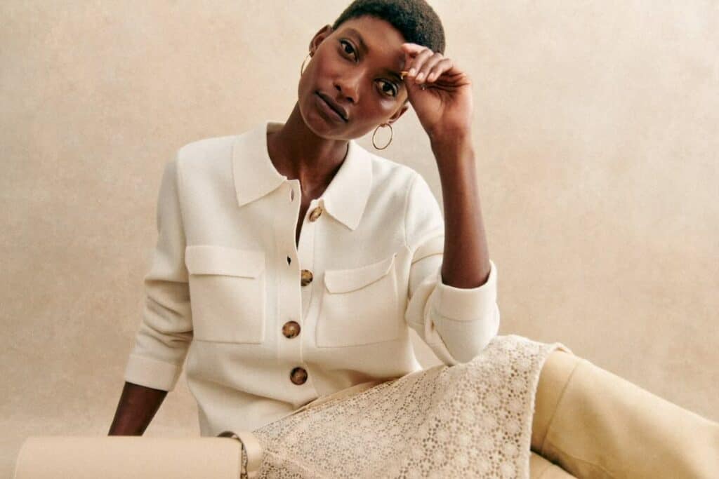sezane black friday - image of model in white sweater and cream skirt copy