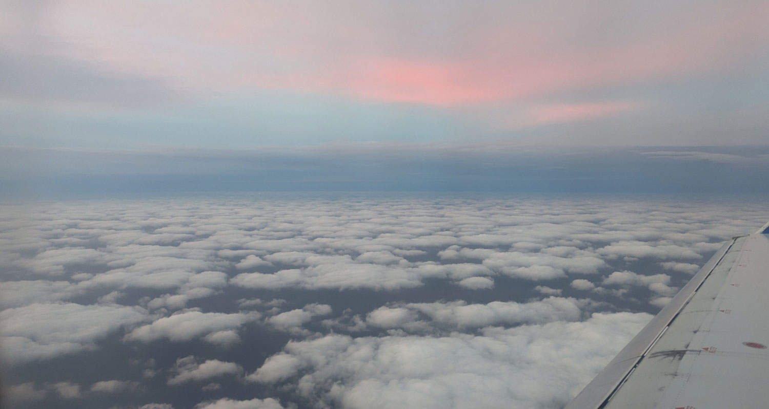 about us - picture of plane above clouds