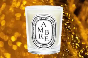 diptyque ambre candle seen on amber colored background