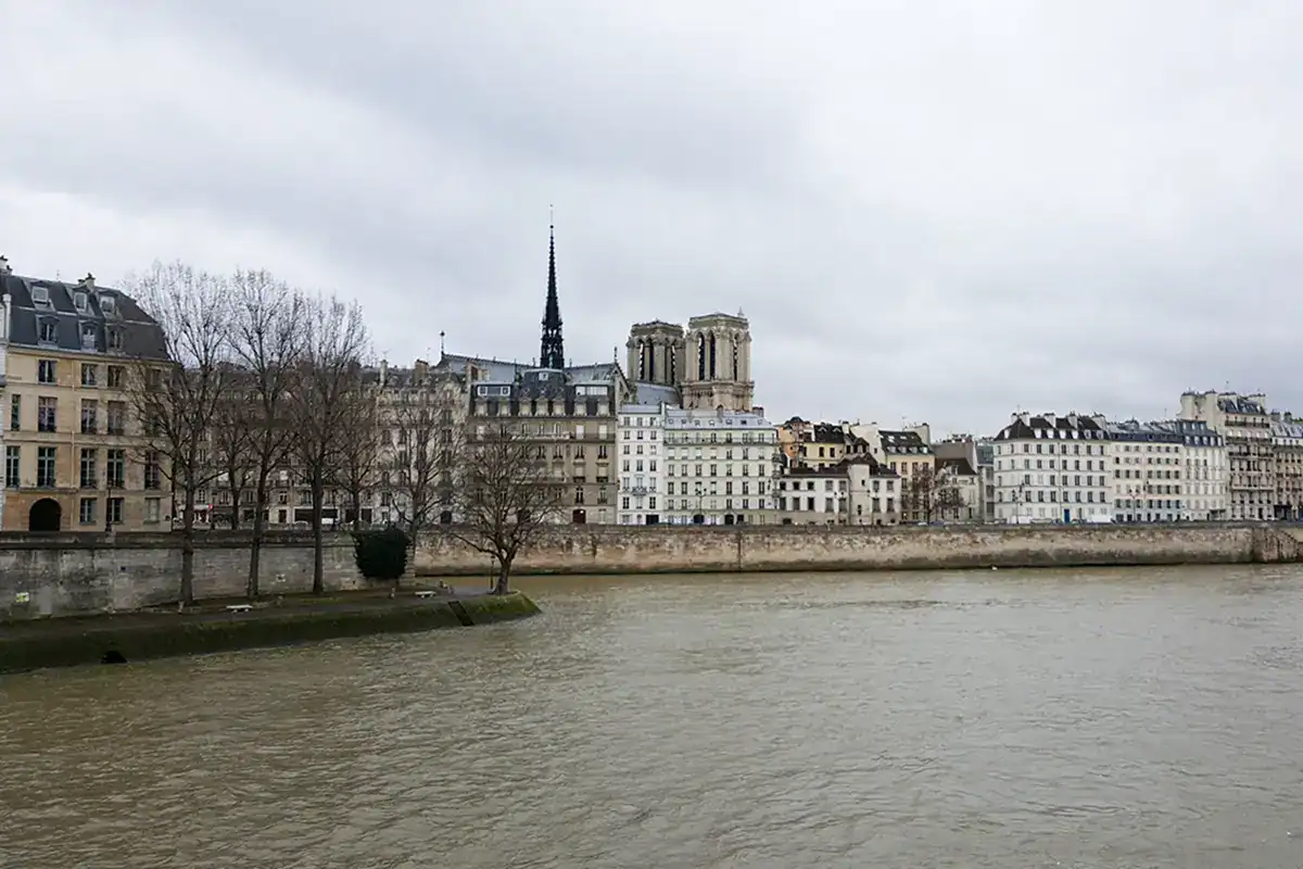 paris in february as seen from the banks of the seine with the towers of notre dame in the background